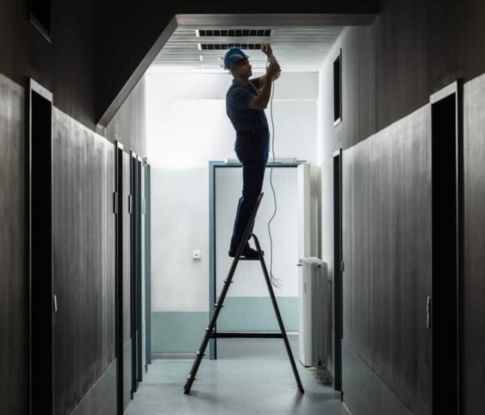 Silhouette,Of,A,Male,Electrician,On,Step,Ladder,Installing,Light